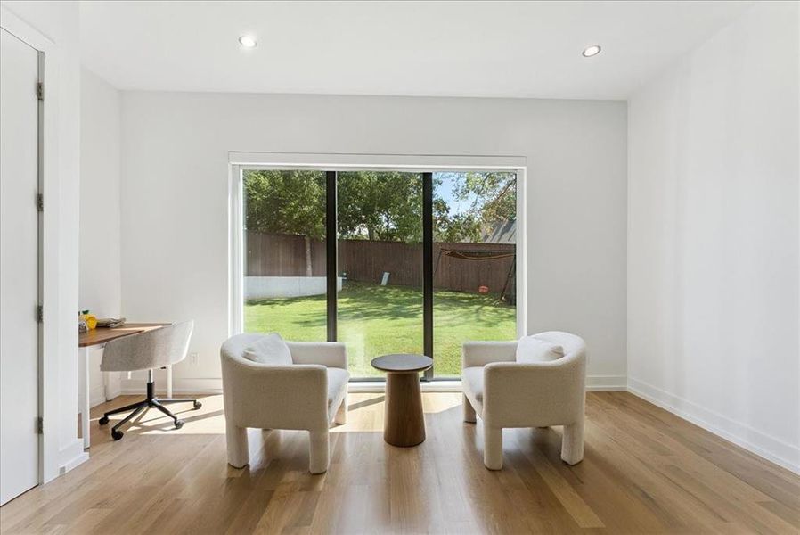 Living area with healthy amount of natural light, light wood-style flooring, and recessed lighting