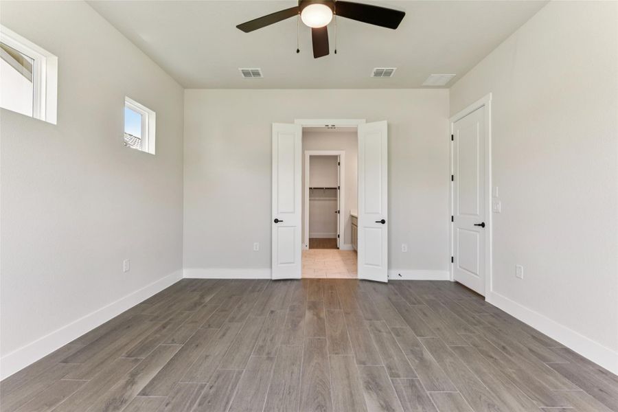 Unfurnished bedroom featuring wood finish floors, a ceiling fan, and ensuite bathroom Unfurnished bedroom featuring wood finish floors, a ceiling fan, and ensuite bathroom