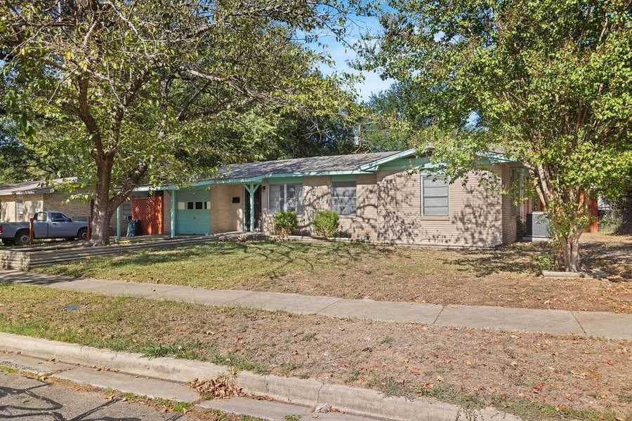 Ranch-style house featuring a garage, brick siding, and a front lawn