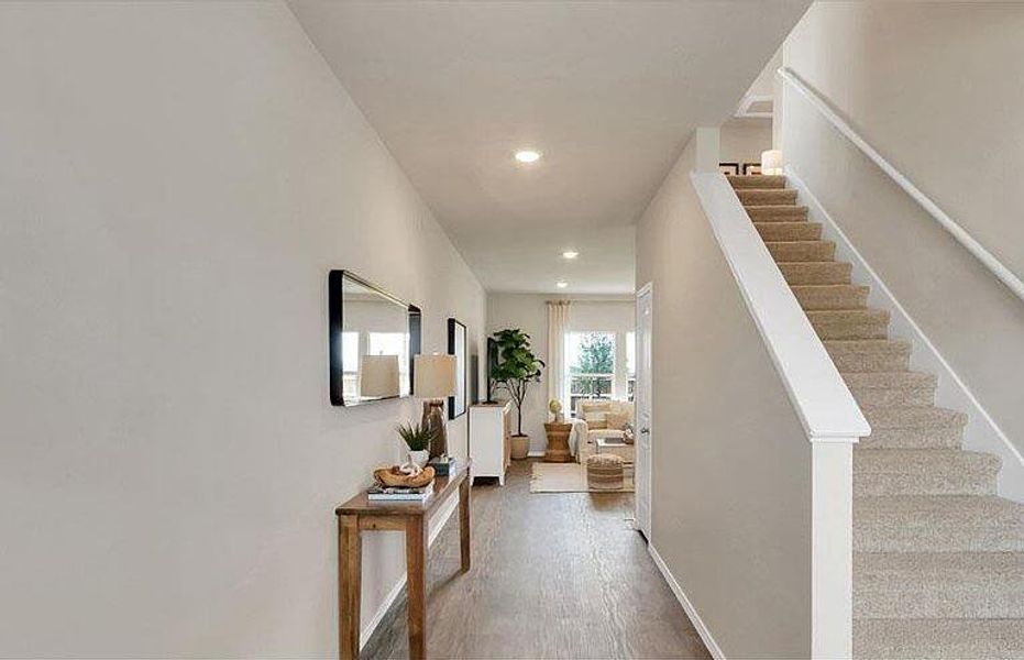 Hallway featuring stairway, wood finished floors, recessed lighting, and baseboards Hallway featuring stairway, wood finished floors, recessed lighting, and baseboards