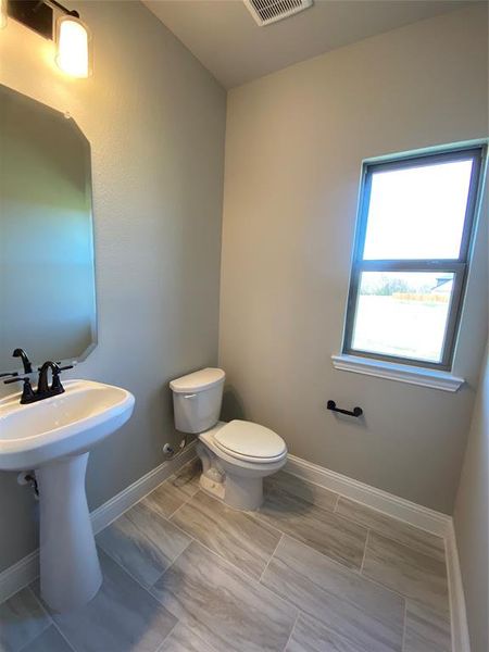 Powder bath downstairs has 12x24 tile and a window
