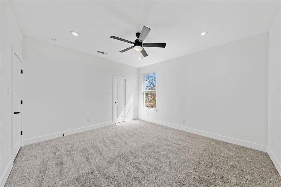 Unfurnished room with baseboards, ceiling fan, visible vents, and light colored carpet