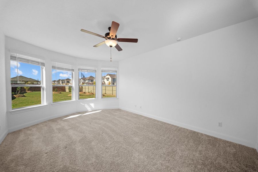 Carpeted spare room with a residential view and ceiling fan Carpeted spare room with a residential view and ceiling fan
