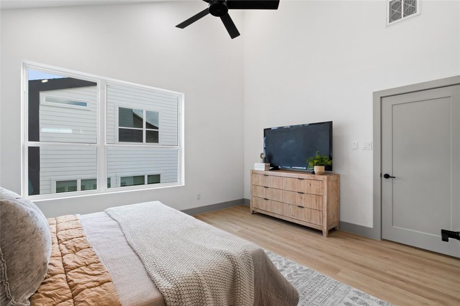 Natural light pours through the oversized windows, enhancing the clean lines and calming tones of this spacious primary suite. Elevated by vaulted ceilings, neutral trim, and wide-plank flooring, it’s the perfect balance of comfort and modern design. Natural light pours through the oversized windows, enhancing the clean lines and calming tones of this spacious primary suite. Elevated by vaulted ceilings, neutral trim, and wide-plank flooring, it’s the perfect balance of comfort and modern design.