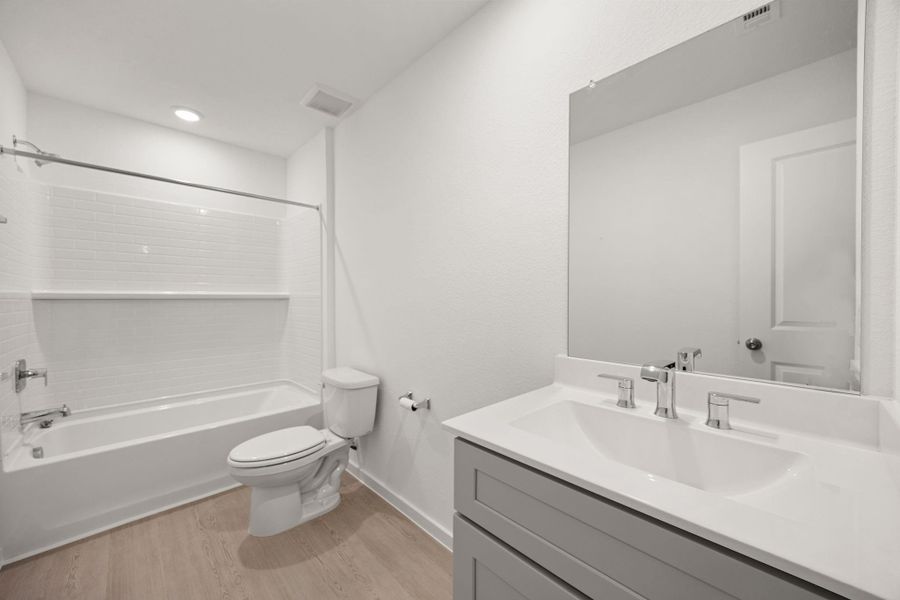 The upstairs full bath features modern finishes, a large vanity with storage, and a tub/shower combination conveniently located near the secondary bedrooms and game room.