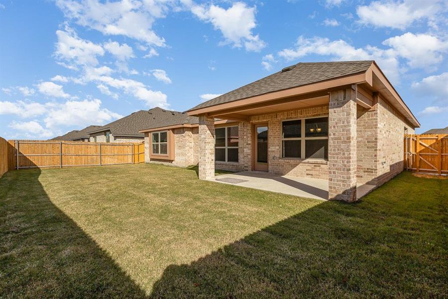 Back of property with a yard and a patio