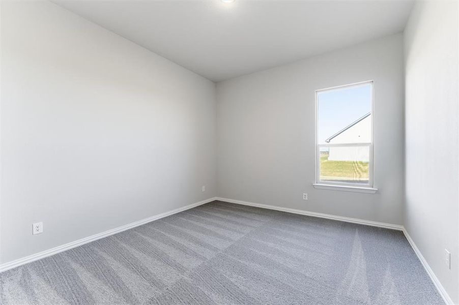 Carpeted empty room featuring baseboards