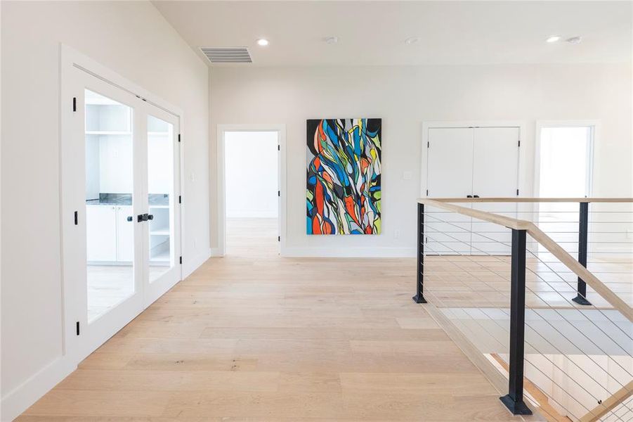 Corridor featuring light hardwood / wood-style flooring and french doors