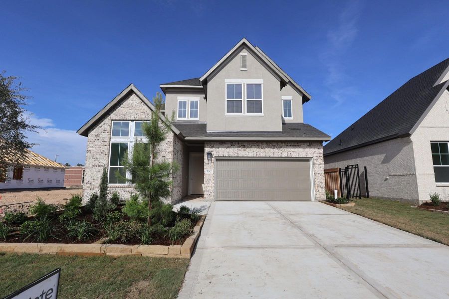 Front exterior of a new home in Woodson’s Reserve, Spring, TX, highlighting curb appeal (Image 1). Front exterior of a new home in Woodson’s Reserve, Spring, TX, highlighting curb appeal (Image 1).