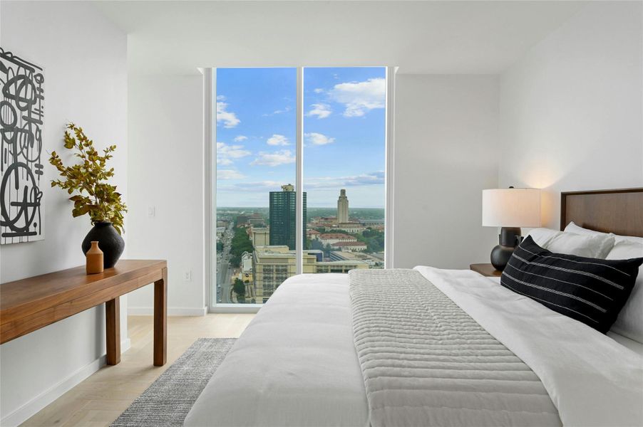 Step into this sleek and contemporary bedroom featuring floor-to-ceiling windows that frame spectacular views of the city and beyond.
