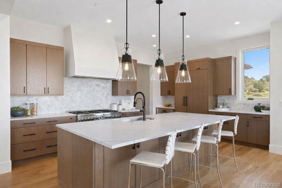 A chef-inspired kitchen anchored by an expansive quartz island, custom cabinetry, and designer lighting.