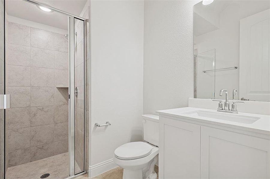 Bathroom with a shower with door, vanity, and toilet