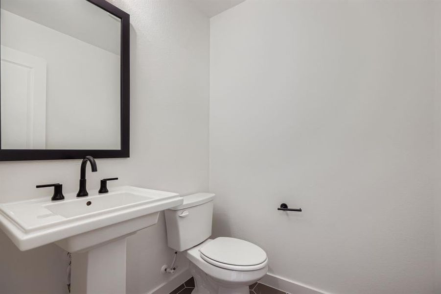 Half bath featuring baseboards and tile patterned floors Half bath featuring baseboards and tile patterned floors