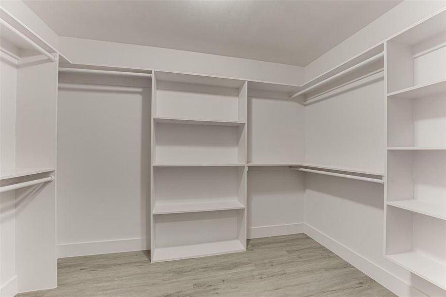 Walk in closet with light wood-type flooring