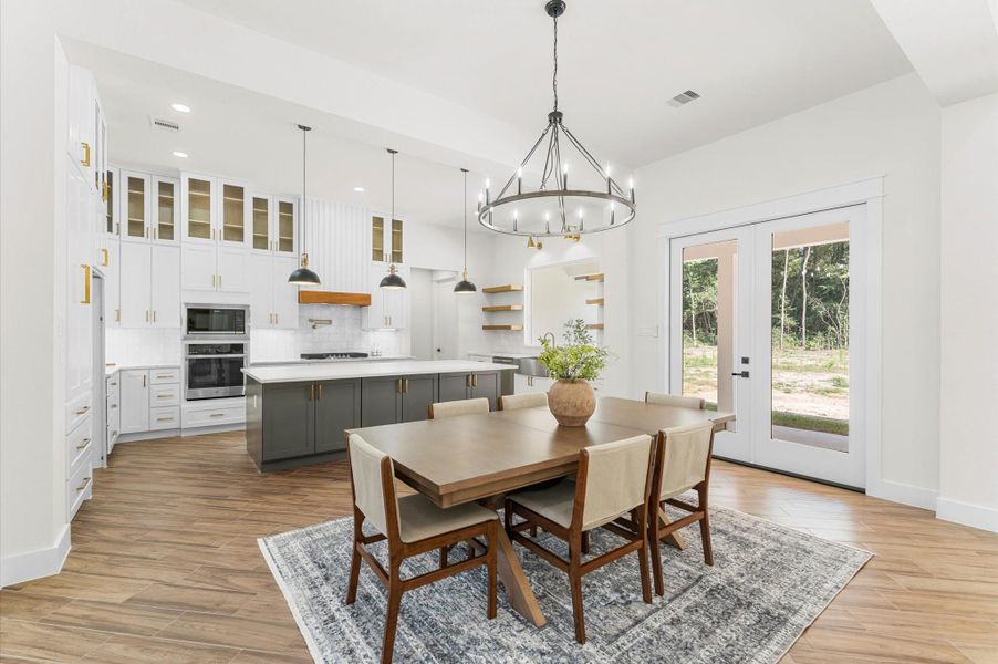 Elegant dining space with seamless connection to kitchen and living, framed by windows and warm wood details. Elegant dining space with seamless connection to kitchen and living, framed by windows and warm wood details.