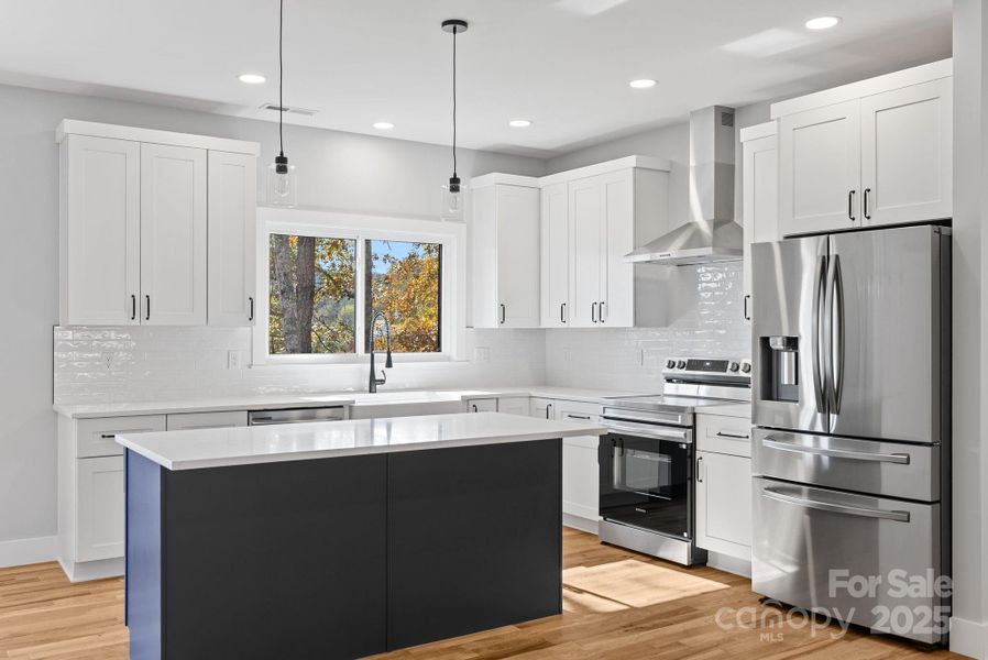 The modern kitchen is clean and fresh and is flooded with natural light.