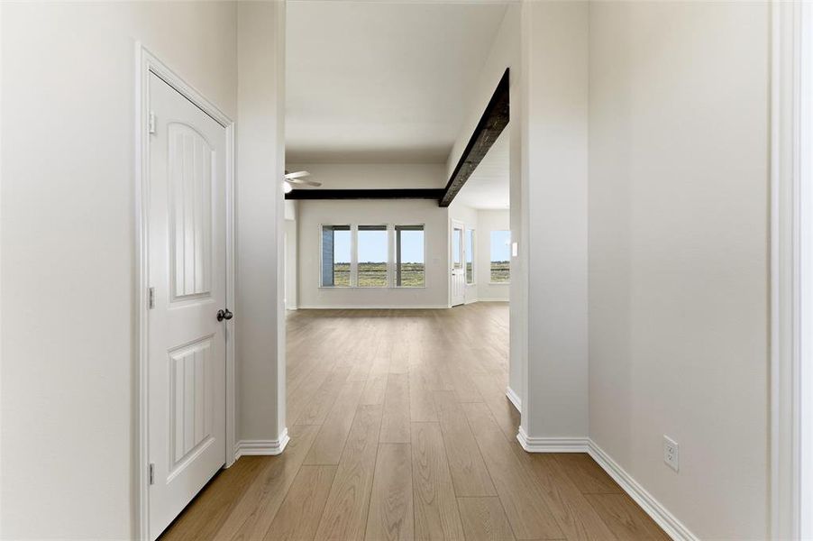 Hallway featuring light wood-type flooring and baseboards