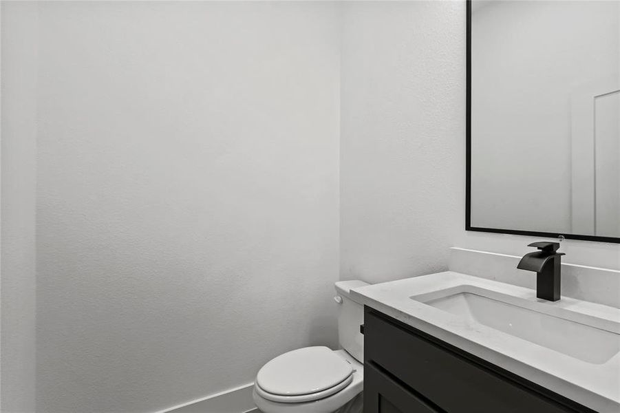 Half bathroom with vanity and a textured wall Half bathroom with vanity and a textured wall