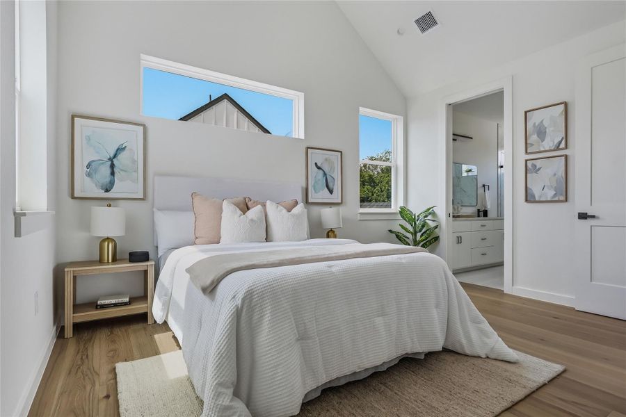 A tranquil primary bedroom features cathedral ceilings.