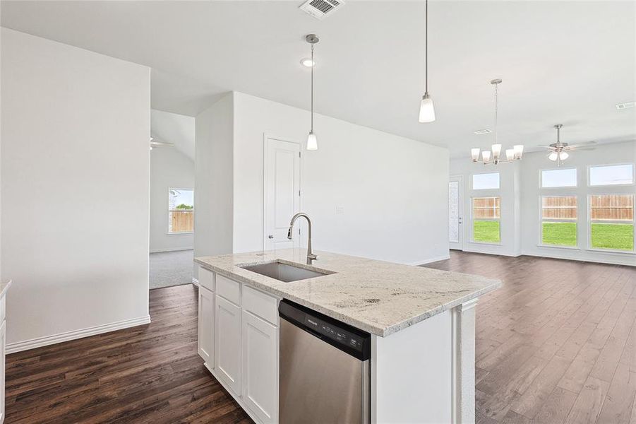 Kitchen with plenty of natural light, sink, stainless steel dishwasher, and white cabinetry