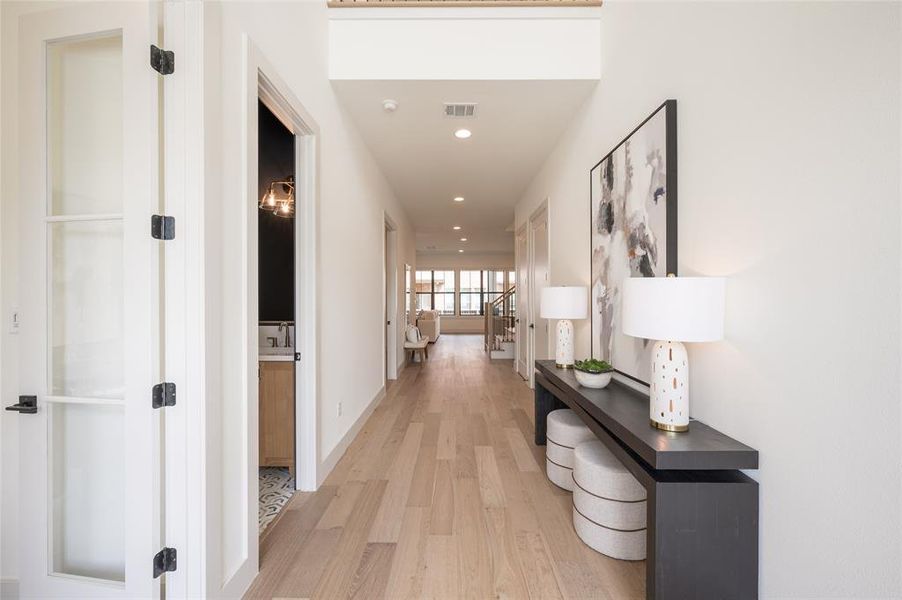 Upon entry, you are greeted by soaring ceilings and abundant natural light. To the immediate left is the office and powder room.