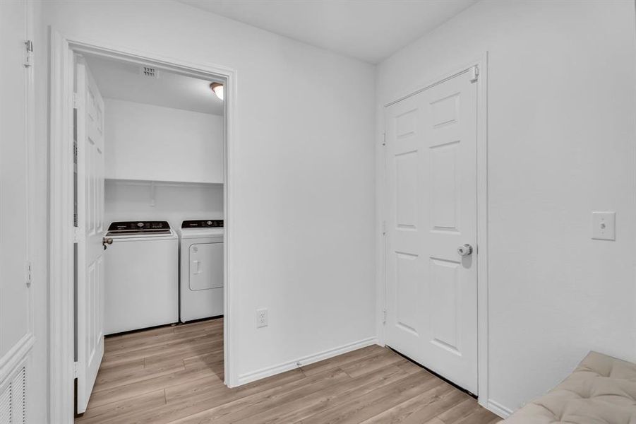 Washroom featuring light wood-style flooring and washing machine and clothes dryer
