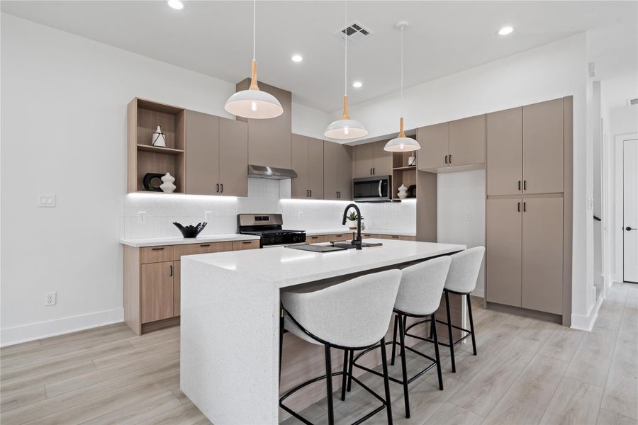The kitchen is a showpiece of both beauty and function, featuring abundant cabinetry and thoughtful storage throughout. An oversized quartz waterfall island anchors the space, offering the perfect spot for cooking, gathering, and creating lasting memories. It’s a true heart of the home designed for modern living.