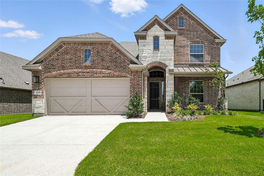 French country home featuring brick siding, concrete driveway, a front lawn, a garage, and a standing seam roof French country home featuring brick siding, concrete driveway, a front lawn, a garage, and a standing seam roof