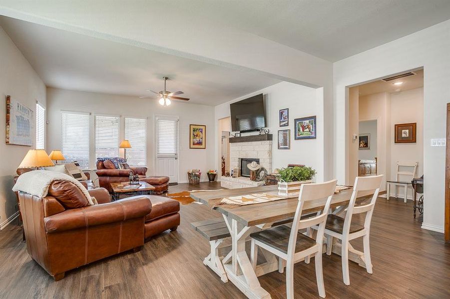 Living area with wood finished floors, a stone fireplace, and a ceiling fan Living area with wood finished floors, a stone fireplace, and a ceiling fan