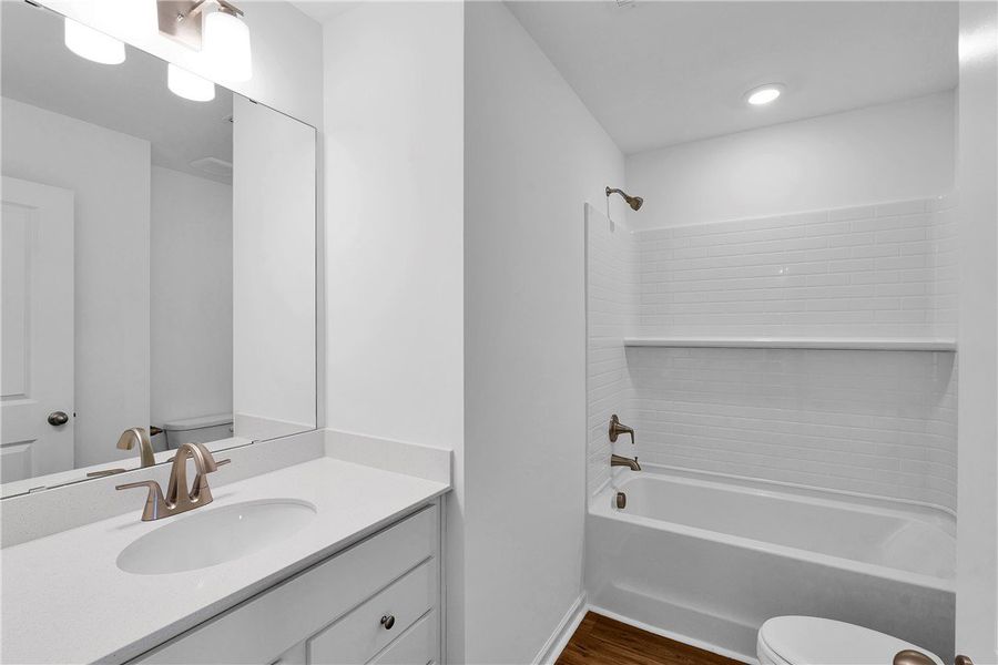 This sleek bathroom features a modern vanity and a This sleek bathroom features a modern vanity and a