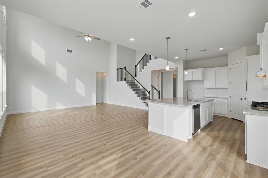 Kitchen featuring a sink, a ceiling fan, open floor plan, and visible vents Kitchen featuring a sink, a ceiling fan, open floor plan, and visible vents