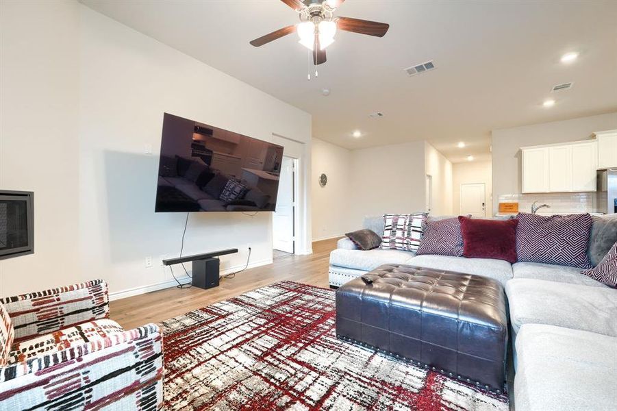 Living area with light wood-style floors, ceiling fan, and recessed lighting Living area with light wood-style floors, ceiling fan, and recessed lighting