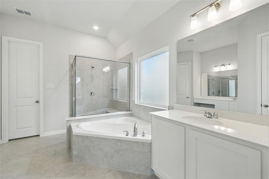 Full bath with a garden tub, vanity, and tiled shower Full bath with a garden tub, vanity, and tiled shower