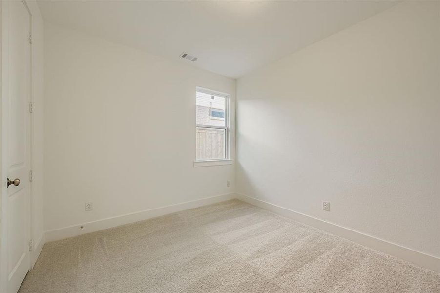 Carpeted empty room featuring baseboards