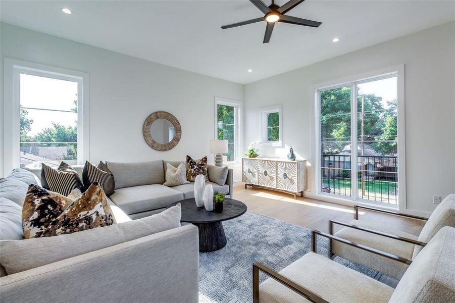 Living room with plenty of natural light, light hardwood / wood-style flooring, and ceiling fan