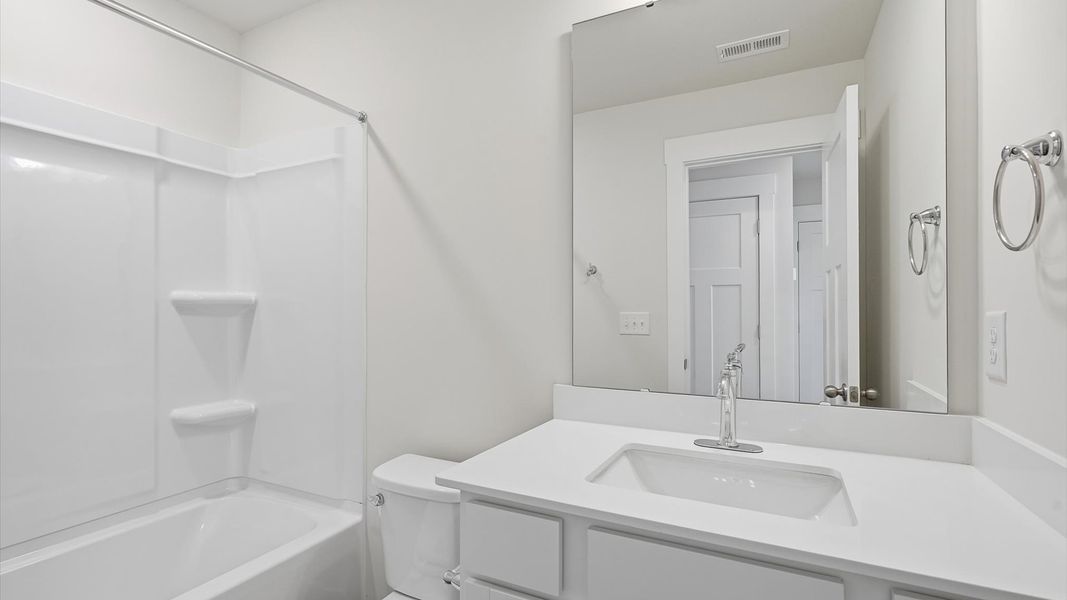 Accomplished bathroom design with sleek tile, high-quality cabinetry, and refined hardware at Clarke Townes