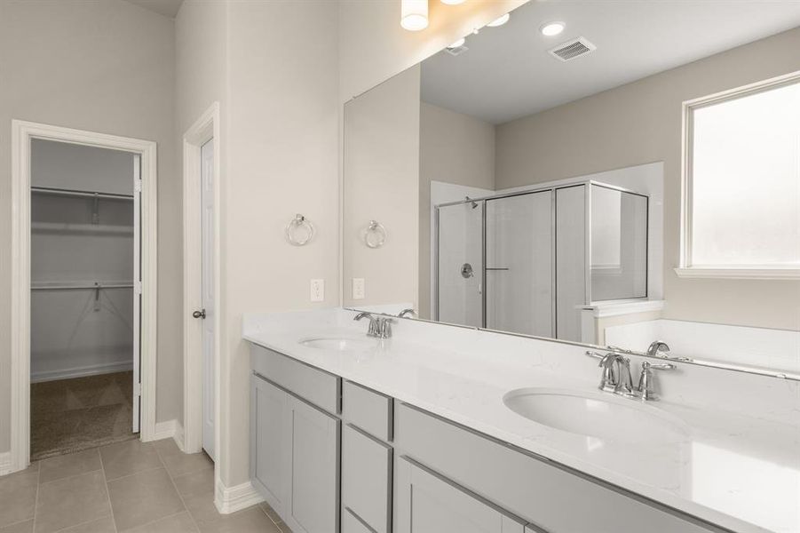 The en-suite bathroom offers a spa-like atmosphere with its elegant design, high end finishes, and tasteful lighting, creating a retreat within your own home.