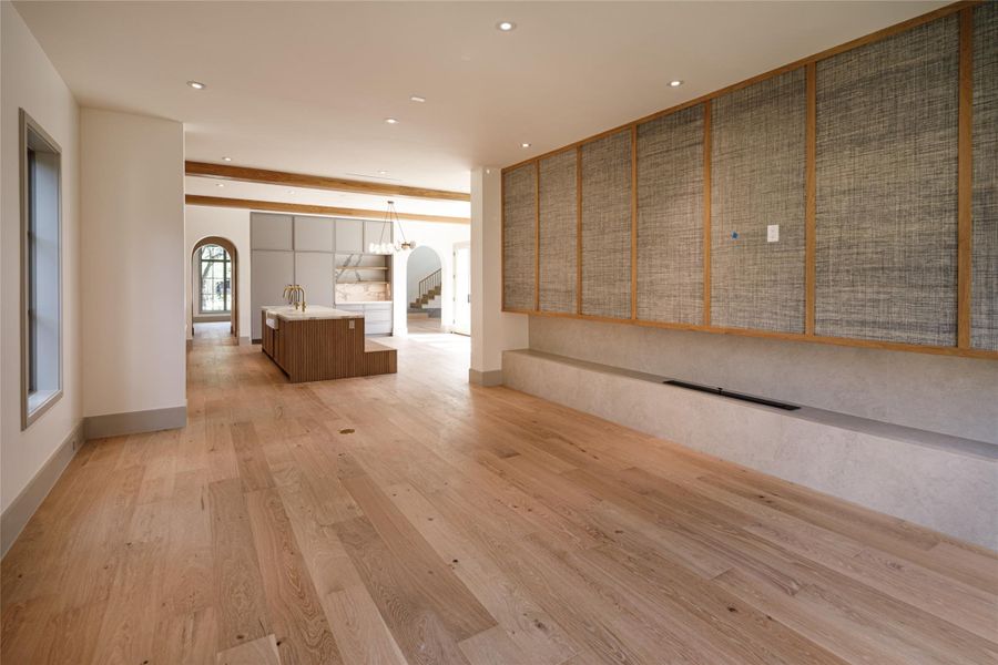 Open concept, without feeling like one giant room. The family room's custom wall gives it its own identity, while the kitchen remains completely connected just beyond it. Proof that an open floor plan can still have definition.