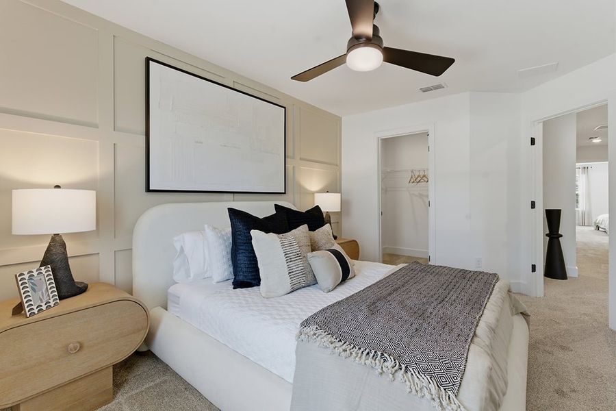 A bedroom with a bed and a fan.