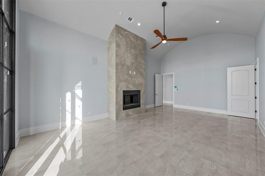 Unfurnished living room featuring a high end fireplace, recessed lighting, ceiling fan, and high vaulted ceiling Unfurnished living room featuring a high end fireplace, recessed lighting, ceiling fan, and high vaulted ceiling