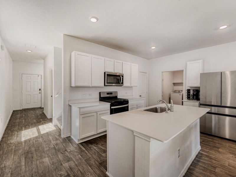 Kitchen with stainless steel appliances, white cabinets, an island with sink, dark wood-style floors, and recessed lighting