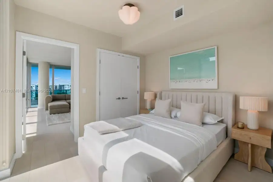 Light-toned wood-finish flooring, white double-door closet with modern hardware, and decorative petal-shaped ceiling light fixture Light-toned wood-finish flooring, white double-door closet with modern hardware, and decorative petal-shaped ceiling light fixture