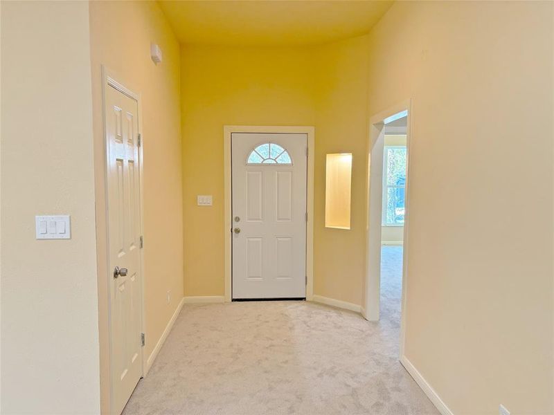 Carpeted entrance foyer featuring baseboards