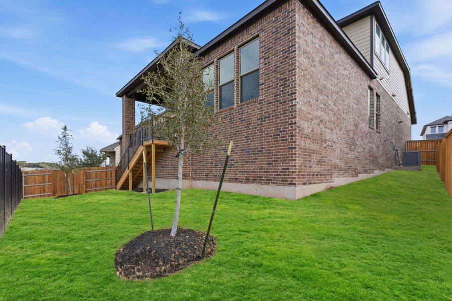 Back of property featuring a fenced backyard and brick siding