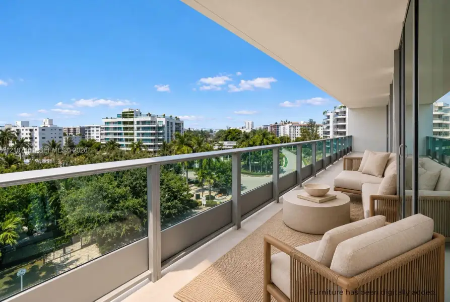 Covered balcony featuring a sleek glass-panel railing, overhead lighting, and expansive urban scenery Covered balcony featuring a sleek glass-panel railing, overhead lighting, and expansive urban scenery