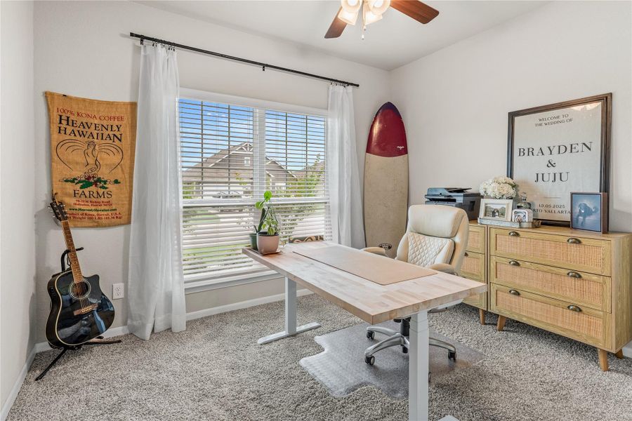 A well-lit home office features plush carpeting and a wooden desk, offering a perfect workspace. A well-lit home office features plush carpeting and a wooden desk, offering a perfect workspace.