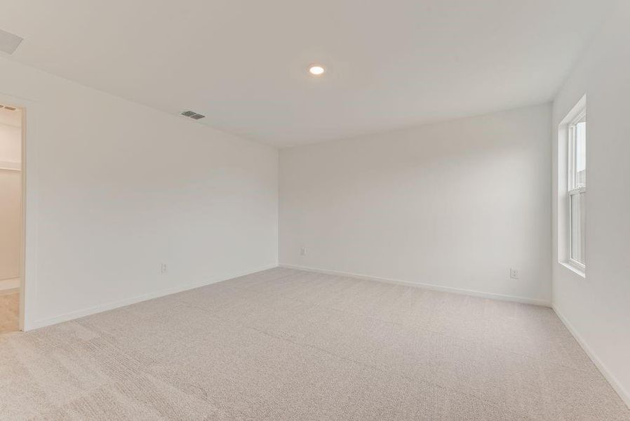 Empty room featuring light colored carpet, visible vents, and baseboards