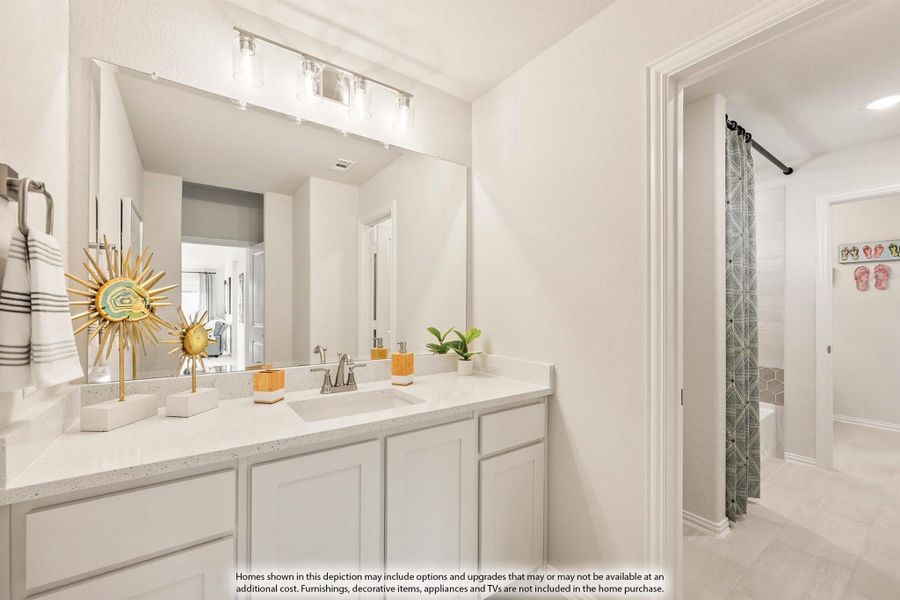 Bathroom with white double vanity, quartz countertop, large mirror, and separate shower area with curtain visible through doorway.