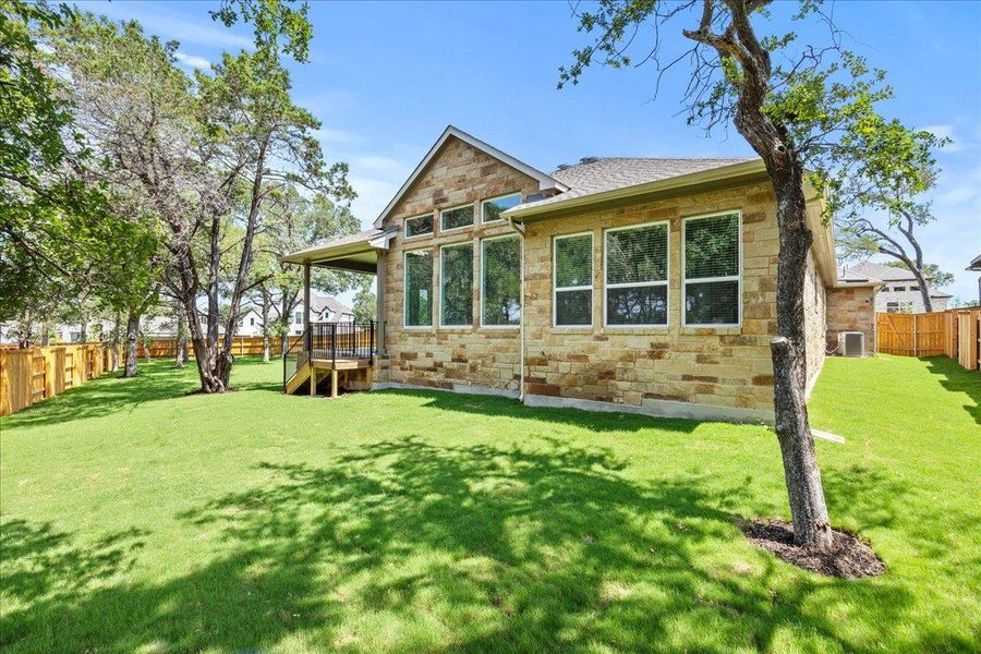 Rear view of house with stone siding and central air condition unit Rear view of house with stone siding and central air condition unit