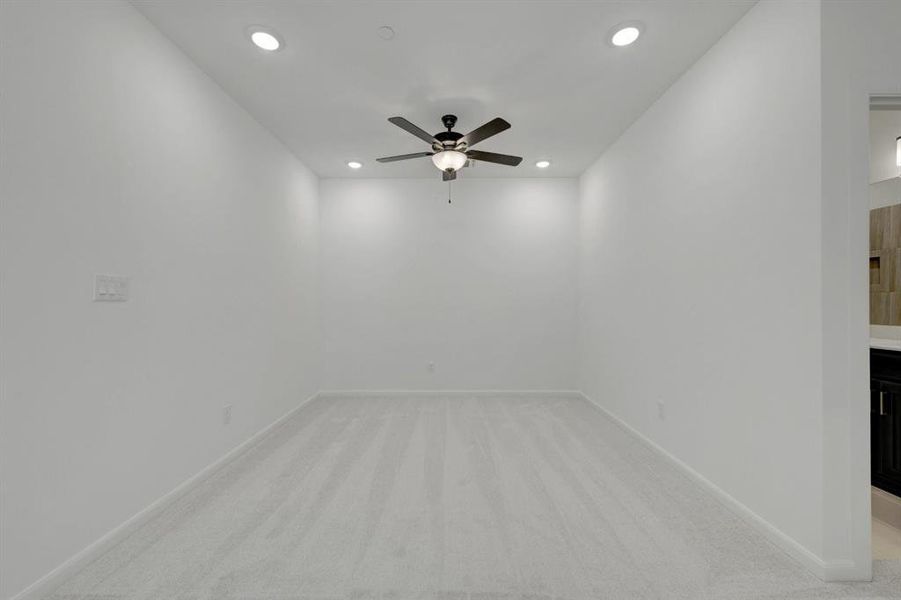 Carpeted room featuring a ceiling fan with integrated lighting and recessed lighting fixtures Carpeted room featuring a ceiling fan with integrated lighting and recessed lighting fixtures